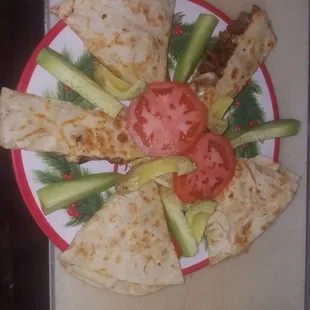 a plate of quesadillas and cucumbers