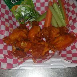 a tray of chicken wings and carrots