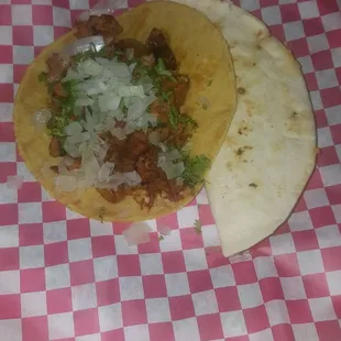 two tacos on a checkered table cloth
