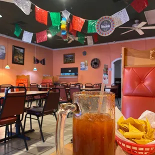 a pitcher of iced tea and a basket of chips