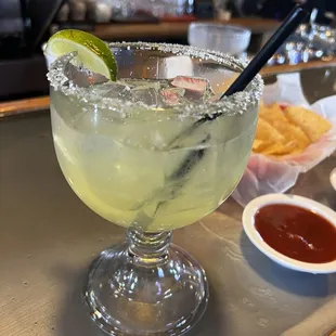 a margarita in a glass with a straw and a lime slice