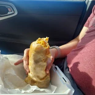 a person holding a sandwich