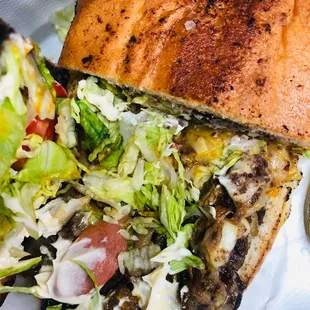 a sandwich with lettuce and tomatoes