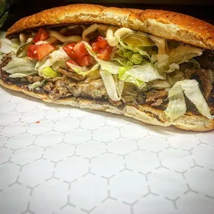 a sandwich with lettuce and tomatoes