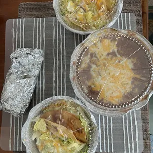 enough food to-go for 2 - 4 people. Bean burrito, two containers with two chicken tacos, each, refried beans.