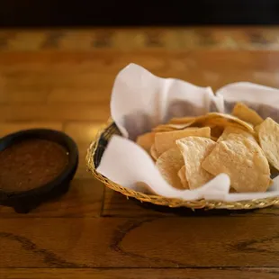 a basket of tortillas and a bowl of salsa