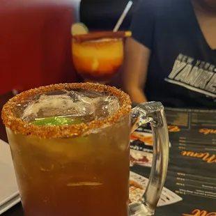 a woman sitting at a table with a drink