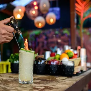 a person using a lighter to make a drink