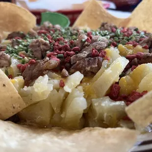 Baked potato with bacon bits cheese and chives topped with molleja.