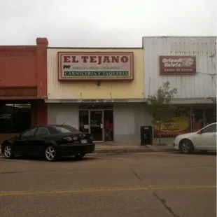 two cars parked in front of a store