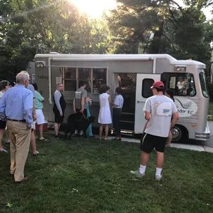 a group of people standing in front of a food truck