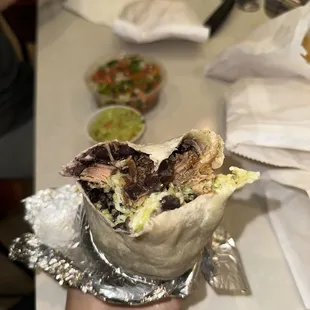 a hand holding a burrito