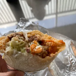 a hand holding a burrito