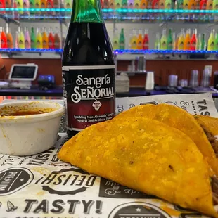 a bottle of beer and three tacos