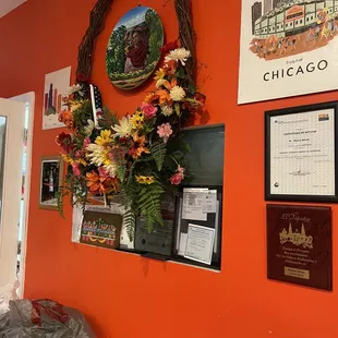 an orange wall with a wreath of flowers