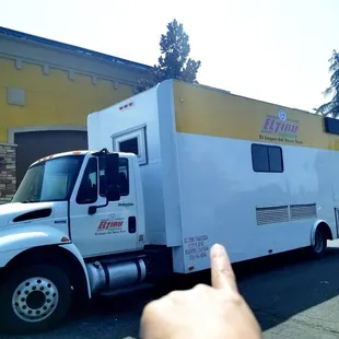 a hand pointing at a food truck