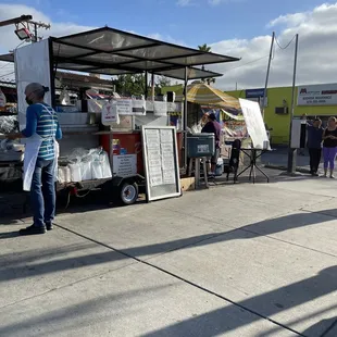 a woman standing in front of a food truck