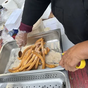 a person preparing churros