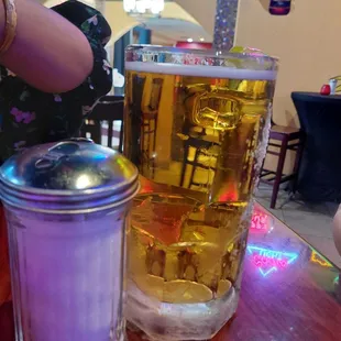 a person sitting at a table with a glass of beer