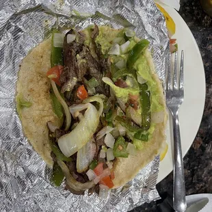 Beef fajita taco w bell peppers, onion, guacamole