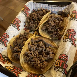 a tray of tacos with meat