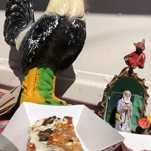 a chicken figurine and a slice of pizza