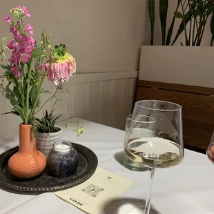 a glass of wine and a vase of flowers