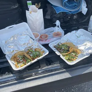 two trays of food in the trunk of a car