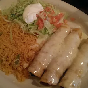 Golden Enchiladas: fried chicken enchiladas covered in cheese sauce with guacamole salad and rice