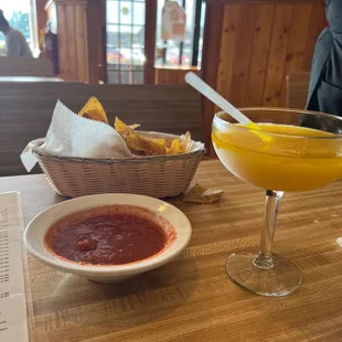 a bowl of salsa and a glass of orange juice