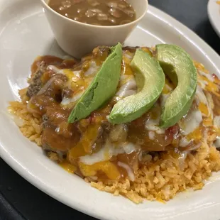 a plate of mexican food with rice and avocado