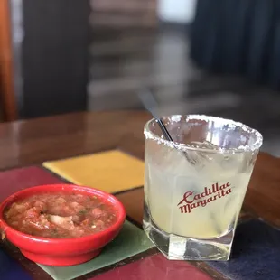 a margarita and a bowl of salsa