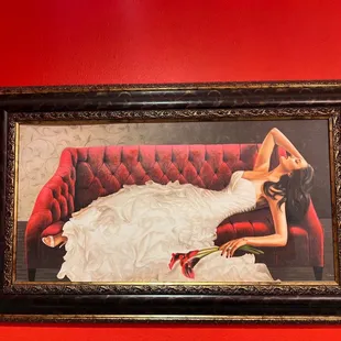 a woman in a wedding dress on a red couch