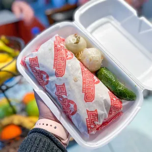 a person holding a container of food