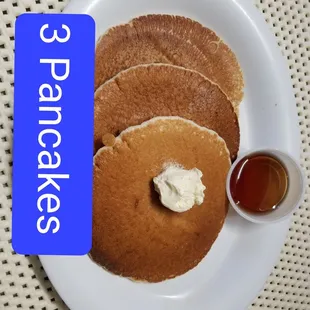 a plate of pancakes with butter and syrup