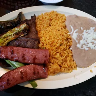 Grilled asada and sausage with beans and rice.