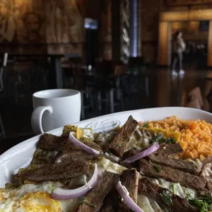 Chilaquiles verdes with steak and two eggs