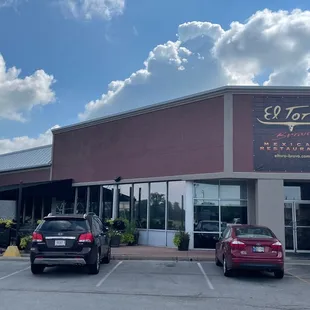 two cars parked in front of a restaurant