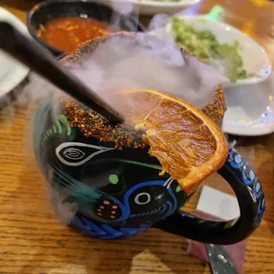 a bowl of soup with a slice of orange