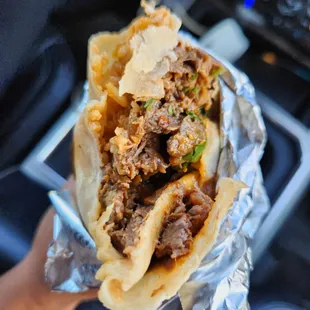 a hand holding a burrito
