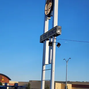 a street sign with a clock on it
