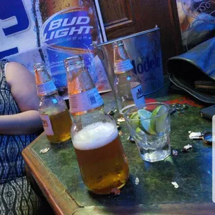 a woman sitting at a table with a beer