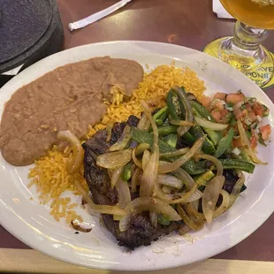 Carne Asada (medium) topped with peppers and onions w/ refried beans and Mexican rice