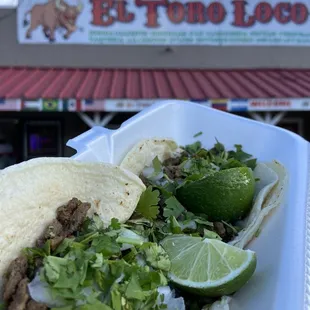 a plate of tacos and lime wedges