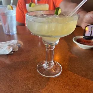 a man sitting at a table with a margarita