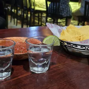 a bowl of chips and two glasses of water