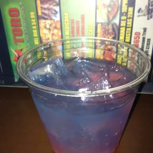 a purple and blue drink in a plastic cup