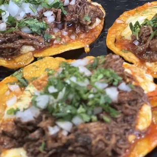 three tacos with meat and onions