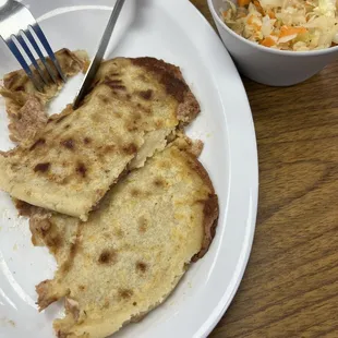 a plate of food and a bowl of coleslaw