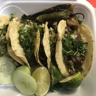 three tacos in a styrofoam container